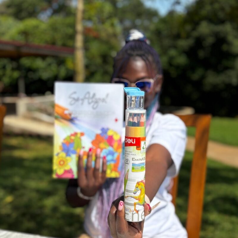 Woman holding the Life Aligned Mindful Coloring Set with affirmations and colored pencils