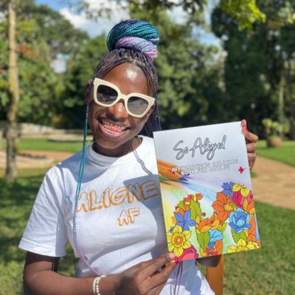 Smiling woman holding coloring book close to chest