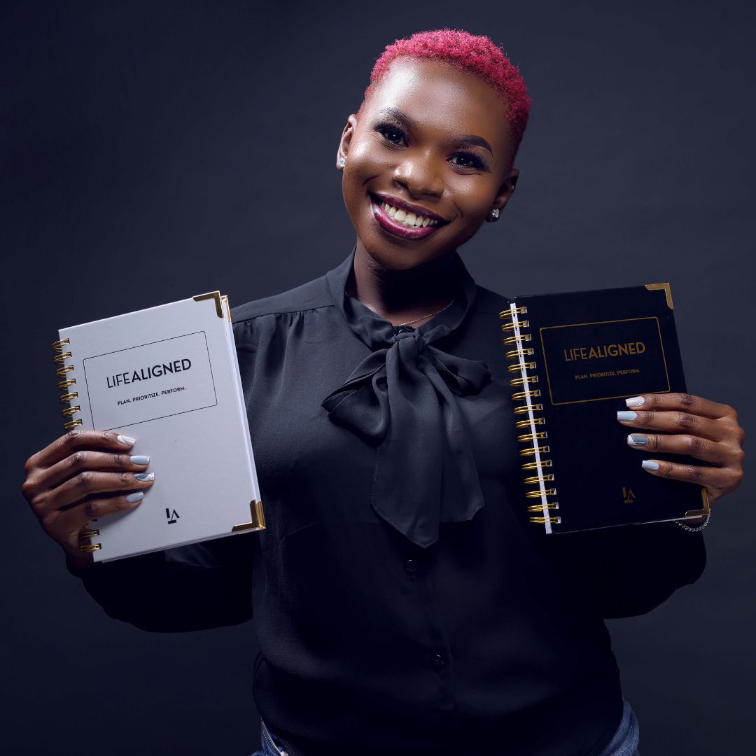 Two planners, grey and black, held side by side by a team member